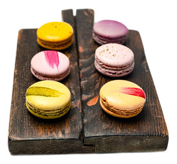 Colorful assorted french macarons on rustic wooden tray with a transparent background, vibrant...
