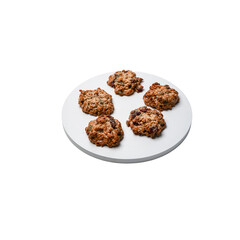Homemade oatmeal cookies with nuts and dried fruits on white plate isolated on transparent background