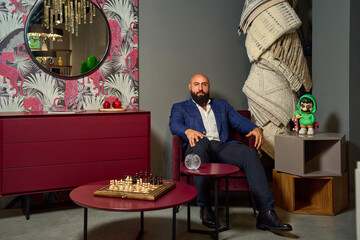 A stylish bearded man in a business suit in an interior