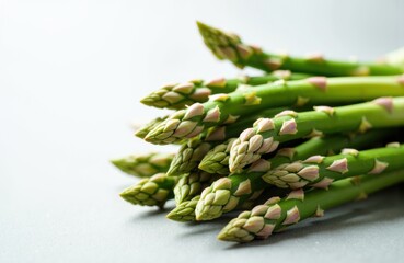 Fresh green asparagus spears arranged on a light surface, ready for cooking or presentation