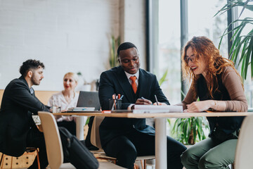 Group of people engaged in a business discussion at a stylish co-working cafe. Collaboration...