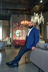 A stylish bearded man in a business suit in an interior