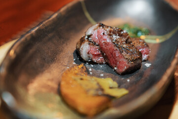 Medium rare grilled wagyu beef steak on ceramic plate