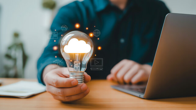 Hand holding glowing lightbulb with cloud symbol technology - Powered by Adobe