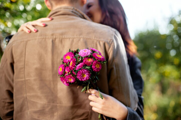 Couple Embracing Outdoors with Flowers in a Romantic Gesture