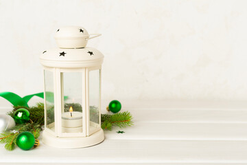 Beige christmas lantern with decorations on wooden table