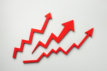Three red upward zigzag arrows with on a light gray background, representing growth, success and...
