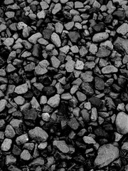 darker small sea stones and gravel background texture with smooth pebbles and coastal rock surface pattern