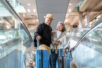 Senior asian traveler couple smiling at airport with suitcases show excitement before travel, retirement lifestyle, planning international journey, travel insurance for elderly, tour and global trip