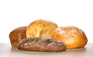 Many diverse bread on a wooden board. Types of homemade bread on the rustic wooden table. Different freshly baked bread on a wooden cutting board. Assorted breads isolated on a white background