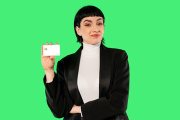 Confident woman showcasing a blank card against a bright green background during a promotional...