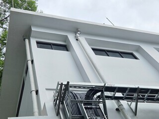 Exterior of a modern white building with piping and structural support in modern design. Great for...