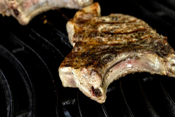 Cooking steak on a gas grill with vegetables.