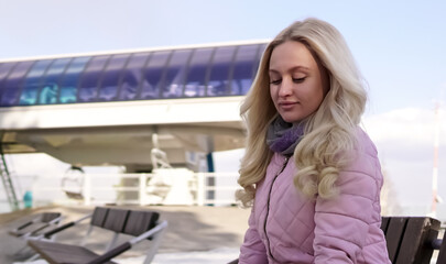 blonde girl sits on a bench and looks down