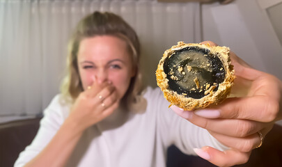 Rotten Chinese black egg close up. Girl plugged her nose.