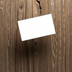 Blank business card sits elegantly on a textured wooden surface creating a rustic and professional template.