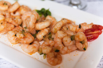 Crispy fried shrimp served on a white plate. Tasty seafood dish, close-up with natural lighting. Concept of gourmet dining, restaurant serving, or home-cooked meal. Fried shrimp on a white plate, seaf