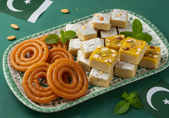 Pakistani Sweets Display for Independence Day Celebration | Jalebi and Barfi on Green Background with Flags for Festive Food Marketing