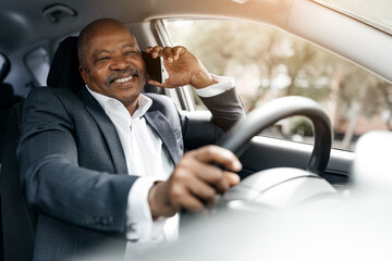 Happy black businessman driving car and talking on phone, multitasking with ease and confidence....