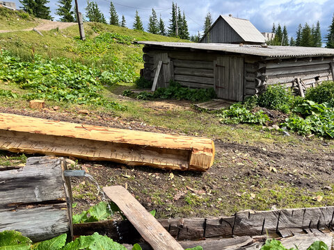 A rustic log cabin in a lush, green countryside setting.