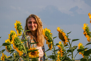 blonde woman in a field of yellow sunflowers, portrait, full face, looking into the lens, smiling,...