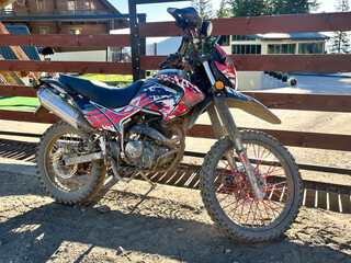 Adventure motorbike parked outdoors by a rustic fence
