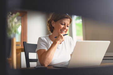 Sad frustrated senior woman pensioner having depressed look, holding hand on her face, calculating...