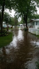 Obraz premium Residential street flooding in neighborhood with trees and white fences