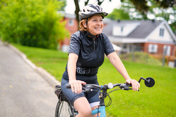 Happy mature cyclist woman enjoying healthy activity