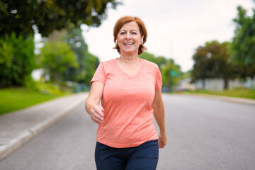 Woman fast walking outdoors with wireless headphones
