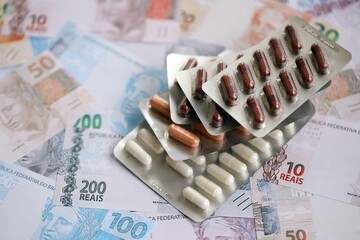 Brazilian reais banknotes and medicine pills. Brazil real money and drugs lies on table