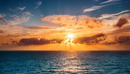 Obraz premium vibrant orange sunset reflects in teal ocean with textured clouds and golden sunlight