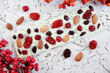 Handmade white chocolate bar with dried fruit and nuts, artisan confectionery flat lay. artisan...
