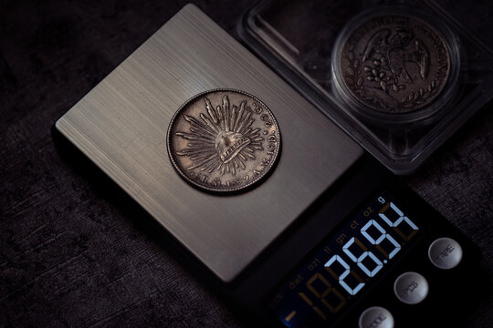 Mexicana silver coins displayed by a digital scale. Ideal for finance, investment, numismatics, or Mexican culturerelated designs.
