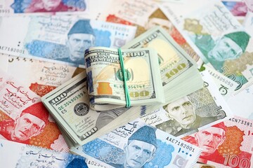 Bunch of US dollar bills lies on big amount of Pakistan rupees banknotes close up