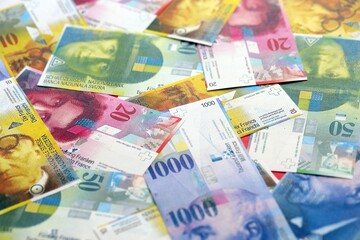 Swiss franc banknotes. The current francs money bills lies on table in big amount