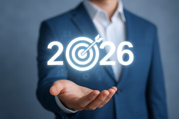 Businessman holding 2026 goal icon with glowing dartboard showing future achievement planning and business target strategy for corporate success and performance projection