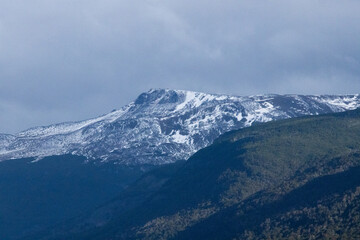 Mountains with snow under a cloudy sky