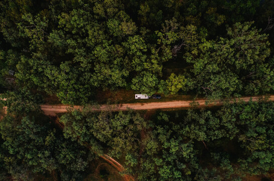 Car with caravan pulled off to the side of dirt trail in forested area in rural NSW Australia