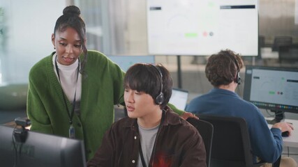 Young business team in tech support call center meeting collaborating with computer headsets in modern office environment supporting seamless communication and teamwork during call center operations - Powered by Adobe