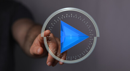 Abstract image of a hand interacting with a futuristic play button interface.  Perfect for...