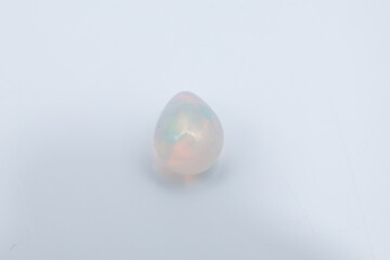 Glowing White Opal Gemstone with Rainbow Play of Color on White Background