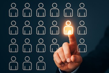 Fototapeta premium A human hand selects a shining candidate icon from a grid, representing recruitment, talent acquisition, and human resources.