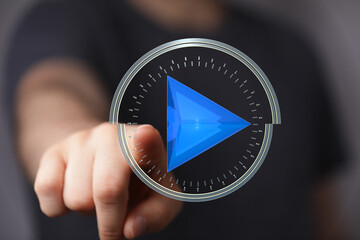 Abstract image of a hand interacting with a futuristic play button interface.