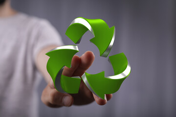 Eco-friendly concept.  Hand holding a 3D recycling symbol. Sustainable future.