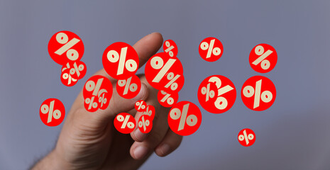 Red percentage symbols hover around a hand, illustrating discounts, sales, or financial growth.