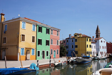 Venice landmark Burano island canal colorful houses and boats Italy.