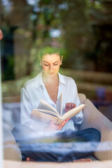 Middle aged woman relaxing at home and reading a book