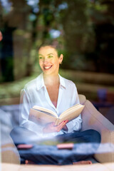 Middle aged woman relaxing at home and reading a book