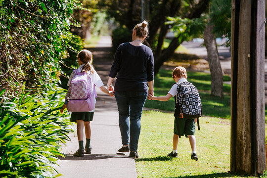 Mother holding hands with her children on walking path